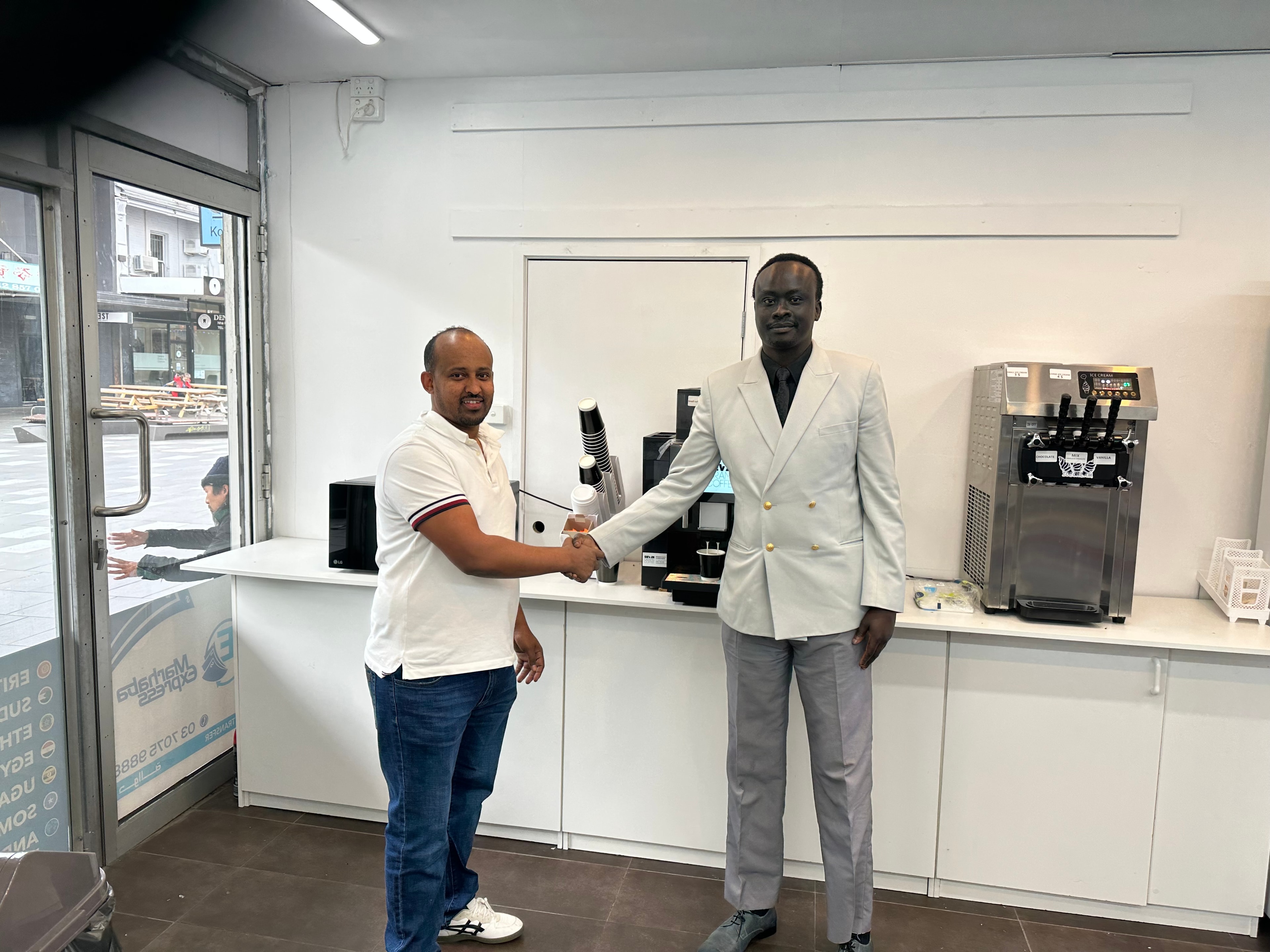 AYC Founder/CEO and the Owner of WOW General Trading Store shaking hands